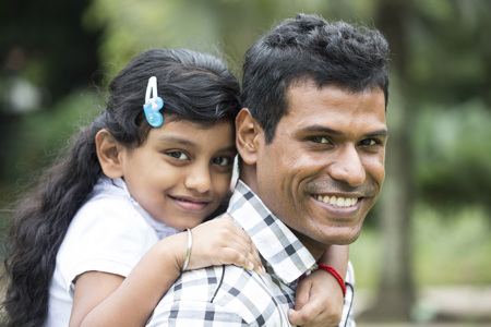 A parent carrying his child on his back. 