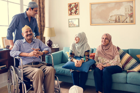 A family sitting on a couch smiling at each other. 