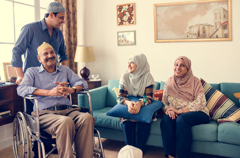 A family sitting on a couch smiling at each other.