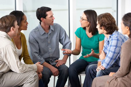 A counselling group sitting together in a circle talking.