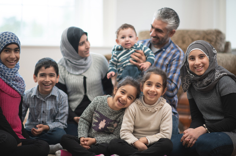 A big family sitting together on the ground.
