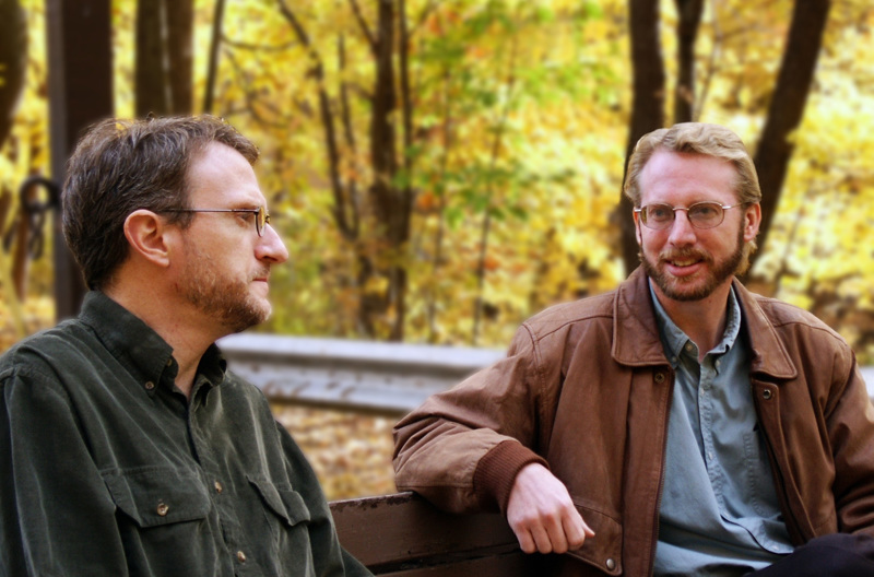 A couple sitting and talking together on a park bench in Autumn