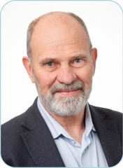 Andrew Bickerdike, a smiling middle-aged man of Anglo-Saxon descent, wearing a grey suit jacket and pale blue collared shirt