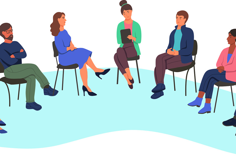 An illustration of a group of people sitting in a circle on chairs talking while one person takes notes on their clipboard.