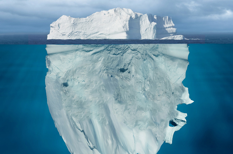 An iceberg, showing that what is beneath the water is a much bigger than what's above the water.