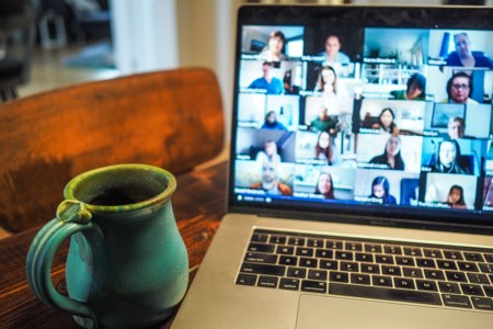 A person on a video call through their laptop talking with another person. 